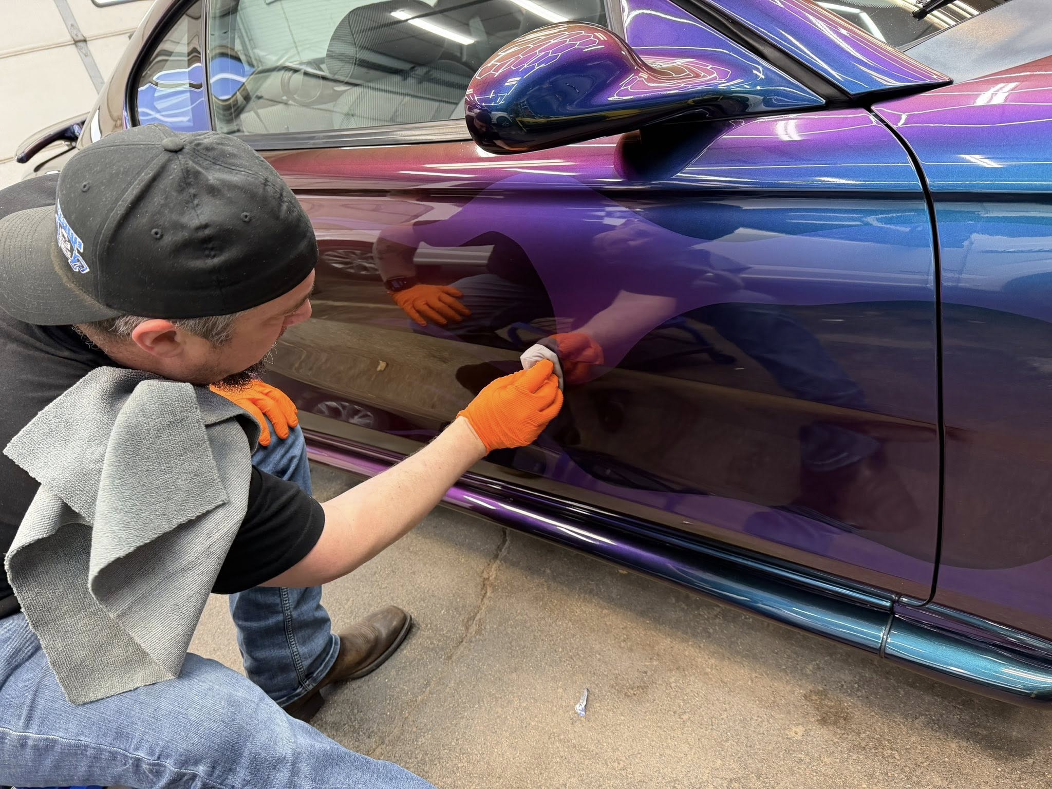 Owner applying Gtechniq ceramic coating to a color-shifting Mustang